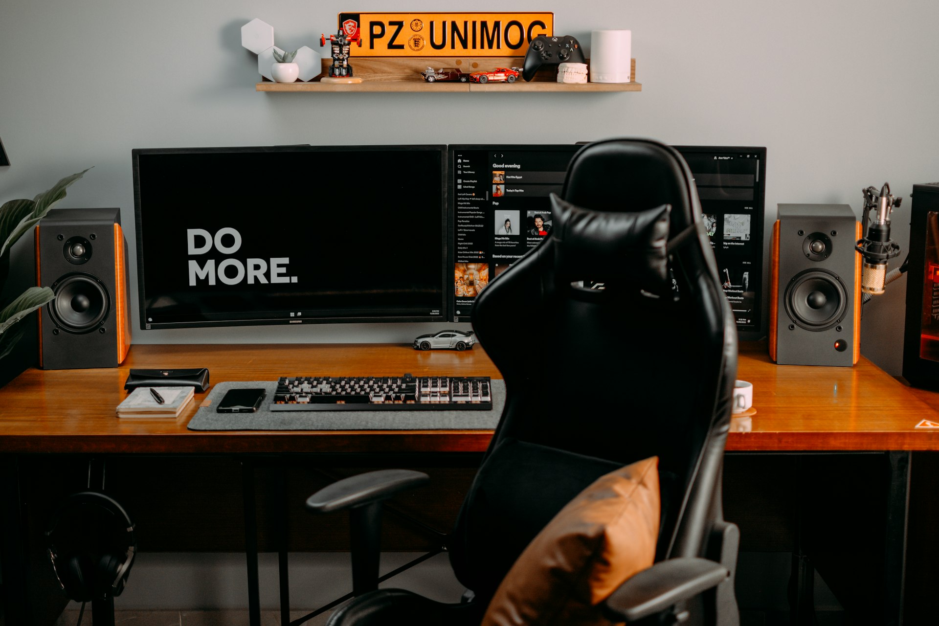 a person sitting at a desk with a computer and speakers